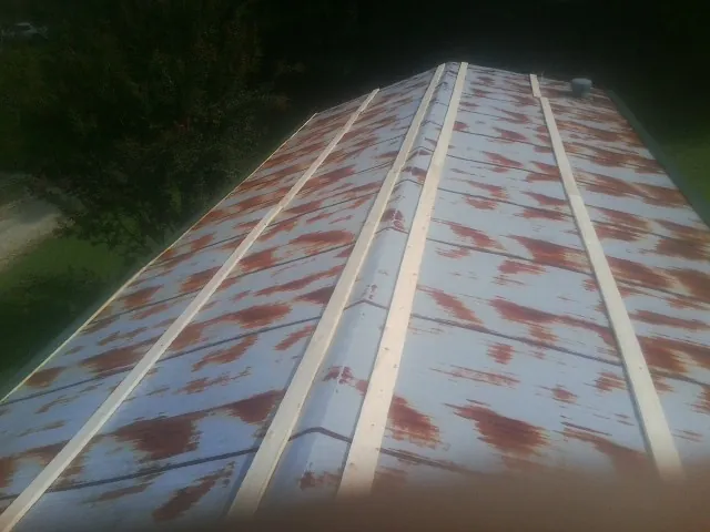 Rusted metal roof panels with new wood purlins before replacement — Storm Damage Roof Repair in Waleska by Roofing Brothers