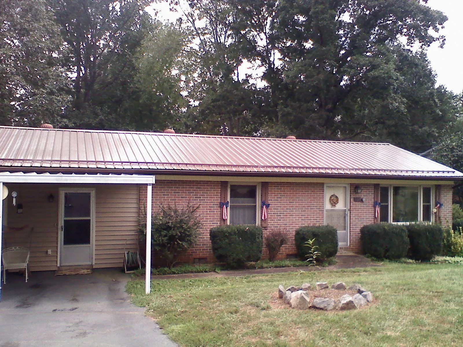 Bronze metal roof and carport on a brick ranch home — Roof Repair work by our crew in Waleska